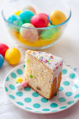 Paskalya masasının arka planında bir tabak kek.