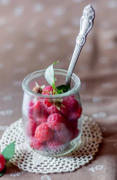 Cam bir kavanozda taze ahududular ve kaşıkla
