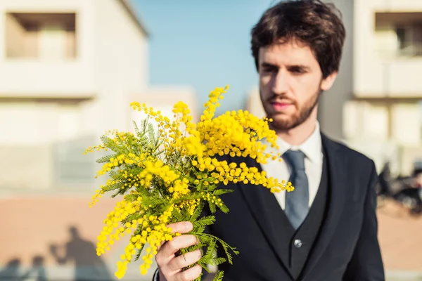 Portrett Mann Dress Med Gule Mimosablomster Utydelig Bybakgrunn – stockfoto