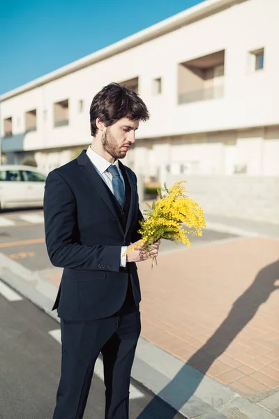 Portrett Mann Dress Med Gule Mimosablomster Utydelig Bybakgrunn – stockfoto