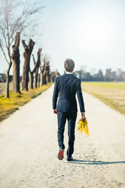 Portrait Man Suit Posing Holding Yellow Mimosa Flowers Blurred Natural — Stok Foto