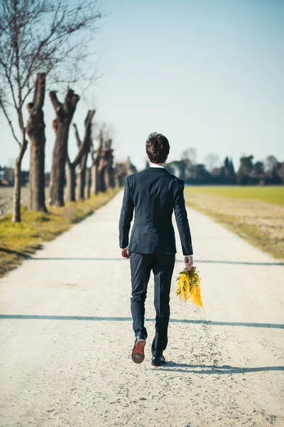 Portrait Man Suit Posing Holding Yellow Mimosa Flowers Blurred Natural — Stok Foto