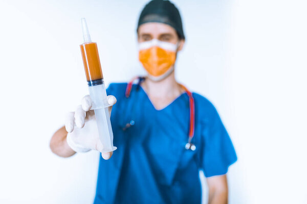 Doctor with syringe posing on white background