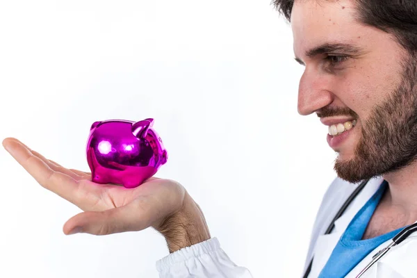 Joven Médico Posando Sosteniendo Alcancía Rosa Aislada Sobre Fondo Blanco —  Fotos de Stock