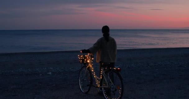 Mujer Disfrutando Puesta Sol Junto Mar Con Guirnalda Bicicleta — Vídeos de Stock