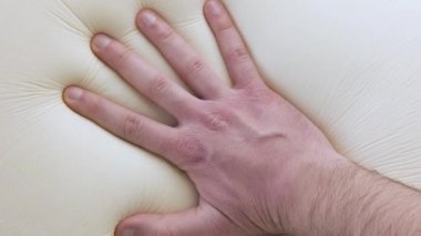 El, modern hafıza köpük yatak ve yastığına dokunup test ediyor.