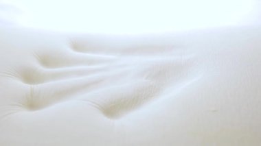 El, modern hafıza köpük yatak ve yastığına dokunup test ediyor.