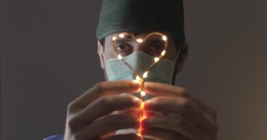 Genç doktor, Coronavirüs hastalarına umut vermek için elindeki kalp sembolünü reddediyor.