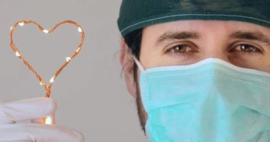 Genç doktor, Coronavirüs hastalarına umut vermek için elindeki kalp sembolünü reddediyor.
