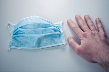 Steril maskenin yanında el ele tutuşan kişi