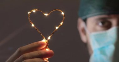 Coronavirus genç doktor ya da hemşire kalp sembolü ile umut veriyor.