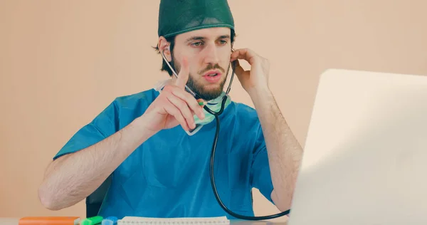 Médico Varón Con Estetoscopio Sentado Mesa Con Portátil —  Fotos de Stock