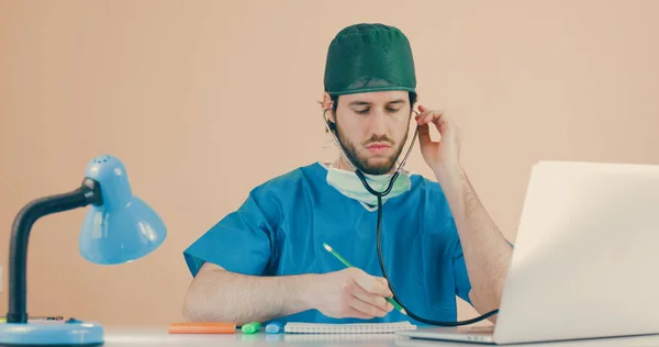 Médico Varón Con Estetoscopio Sentado Mesa Con Portátil —  Fotos de Stock