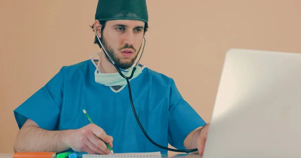 Médico Varón Con Estetoscopio Sentado Mesa Con Portátil —  Fotos de Stock