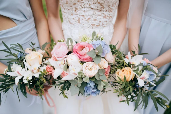 Pengantin wanita dan pengiring pengantin memegang karangan bunga — Stok Foto