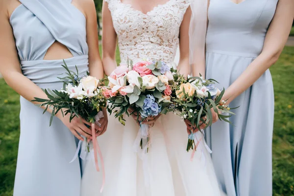 Novia y damas de honor sosteniendo ramos — Foto de Stock