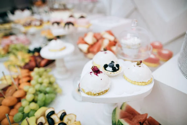 テーブルいっぱいのお菓子や料理の結婚式の夕食は 砂漠の棒キャンディ — ストック写真