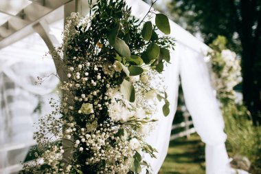 Beautiful arch with fresh flowers for the wedding ceremony in the summer garden