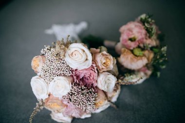 Gri arka planda narin güllerden bir gelin buketi