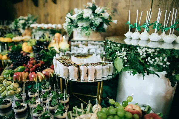 Bruiloft tafel met hapjes en fruit en desserts bij de ceremonie, catering — Stockfoto