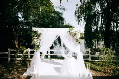 Beautiful arch with fresh flowers for the wedding ceremony in the summer garden