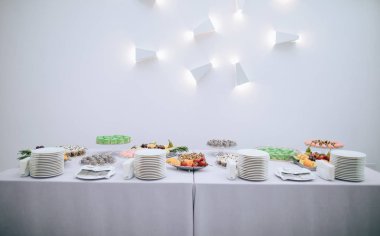 Tatlı yiyeceklerle dolu bir masa. Beyaz arka plandaki düğün partisinde nefis kekleri olan güzel bir çikolata.