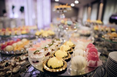 Güzel bir düğün tatlısı, pembe, sarı pastalar düğün resepsiyonunda,