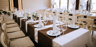 Şarap kadehleri ve yemek servisi olan bir restoranda zarif bir masa.