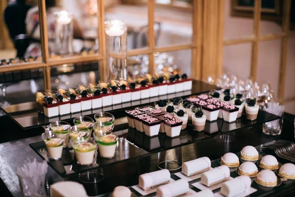 Красивий цукерковий бар зі смачними ожиновими тортами на весіллі — стокове фото