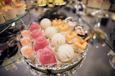 Tatlı yemek. Ayna masasında sarı ve pembe kekler olan zarif bir çikolata.