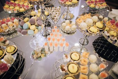 Düğün tatlısı. Ayna masasında sarı ve pembe kekler olan zarif bir çikolata.