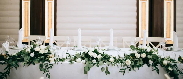 Beautiful table decoration with green leaves and gold candlesticks