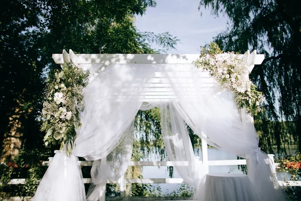 Vacker båge med färska blommor för bröllopsceremonin i sommarträdgården — Stockfoto
