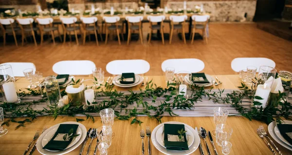 Catering, juego de mesa. Hermosa decoración de mesa en un restaurante con hojas verdes y velas — Foto de Stock
