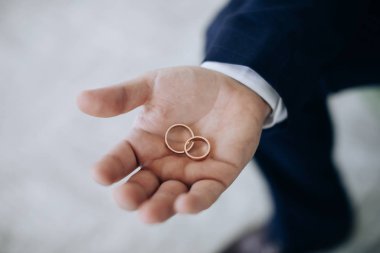 The groom holds wedding rings in his hands. Wedding ceremony