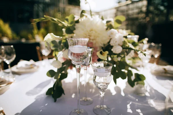 Kaarsen en verse bloemen op tafel. Prachtige tafeldecoratie voor een feestelijk romantisch diner buiten — Stockfoto