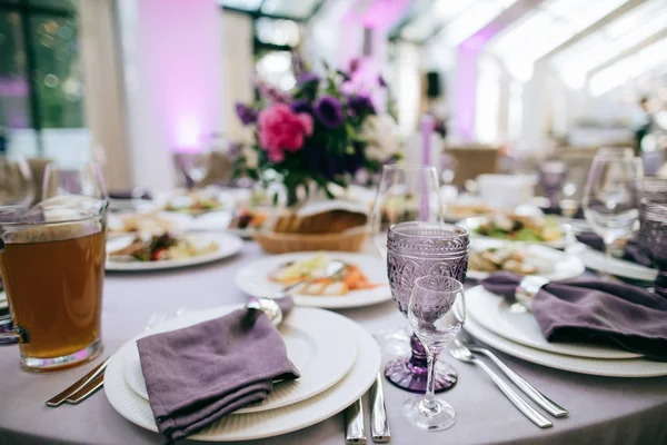 Mesa festiva con comida en plato y flores púrpuras —  Fotos de Stock