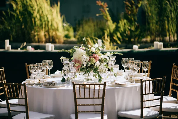 Hermosa cena romántica en el jardín de verano. Mesa decorada con flores y velas. Restauración al aire libre — Foto de Stock