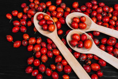 Kırmızı gül kalçalar ahşap kırsal masa üzerinde yabani gülün meyvesi.. 