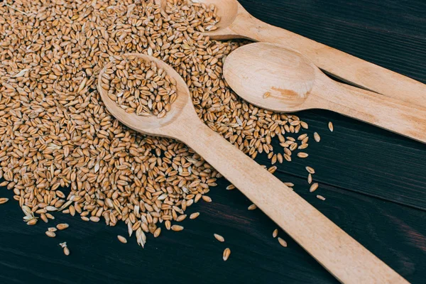 Raccolta del grano. Grani secchi maturi su fondo di legno — Foto Stock