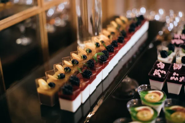 Düğün partisinde tatlı masasında taze böğürtlenli lezzetli kekler.