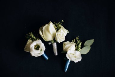 Damat ve arkadaşları için beyaz güllerden yapılmış düğün yaka çiçekleri.