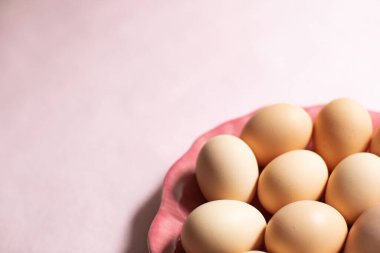 Pembe arka planda taze yumurta tabağı.