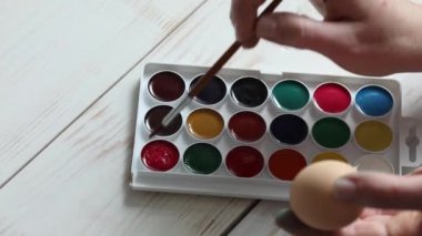 Kadın kırmızı boyalarla resim yapıyor. Palet