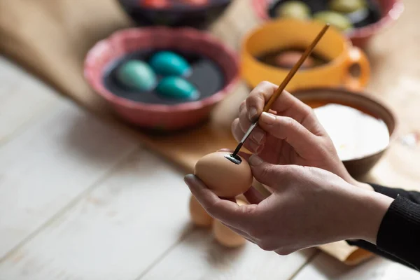 Woman painting eggs for Easter with funny patterns. Easter decoration