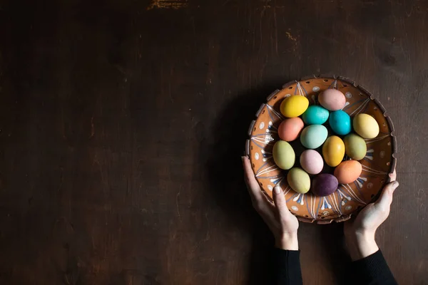 Woman holding colorful Easter eggs in her hands. Space for text