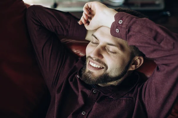Young Bearded Man Relaxing Sofa Office Hours Smiling — Stock Photo, Image