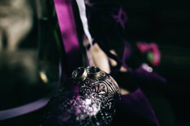 Alyanslar mor camda. Aşk konsepti. Düğün aksesuarları