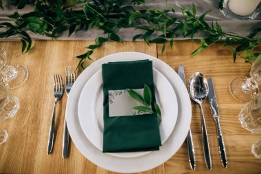 Tahta masada çatal ve bıçakla kaplanmış bir tabak.