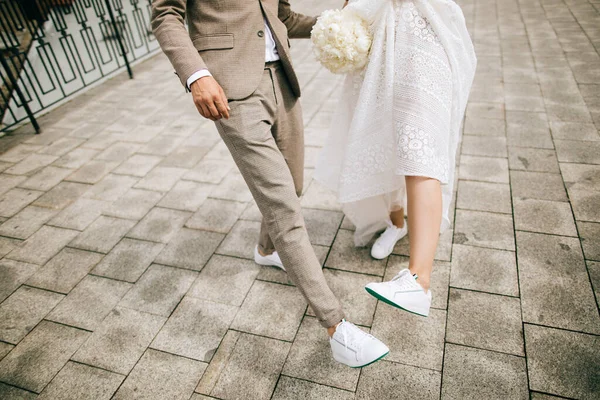 通りの花嫁と新郎は彼らの靴を見る 古典的な結婚式の靴じゃない — ストック写真